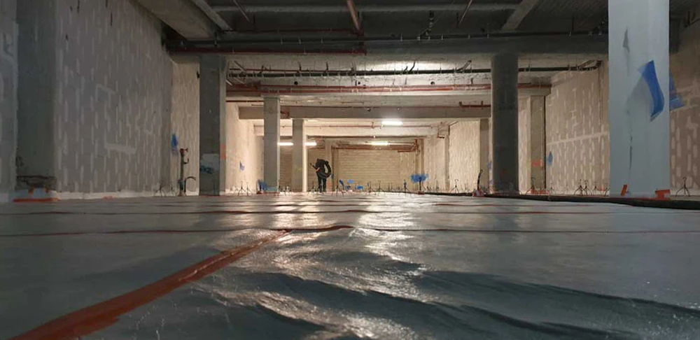 Chantier intérieur en sous-sol, un ouvrier debout au fond
