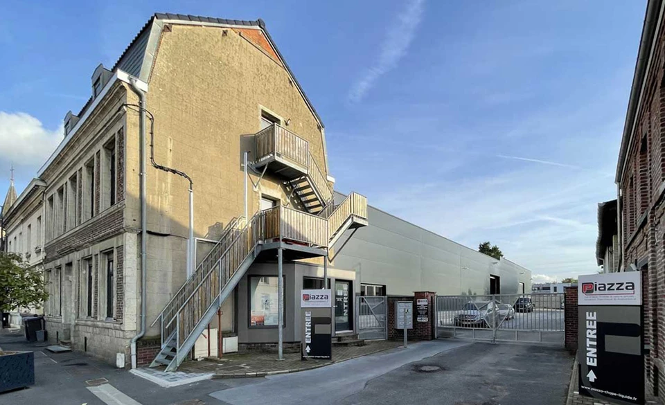 Entrepôt industriel intérieur abritant plusieurs véhicules utilitaires Ford Transit blancs marqués **Piazza Bâtiment**, spécialisés en chape liquide