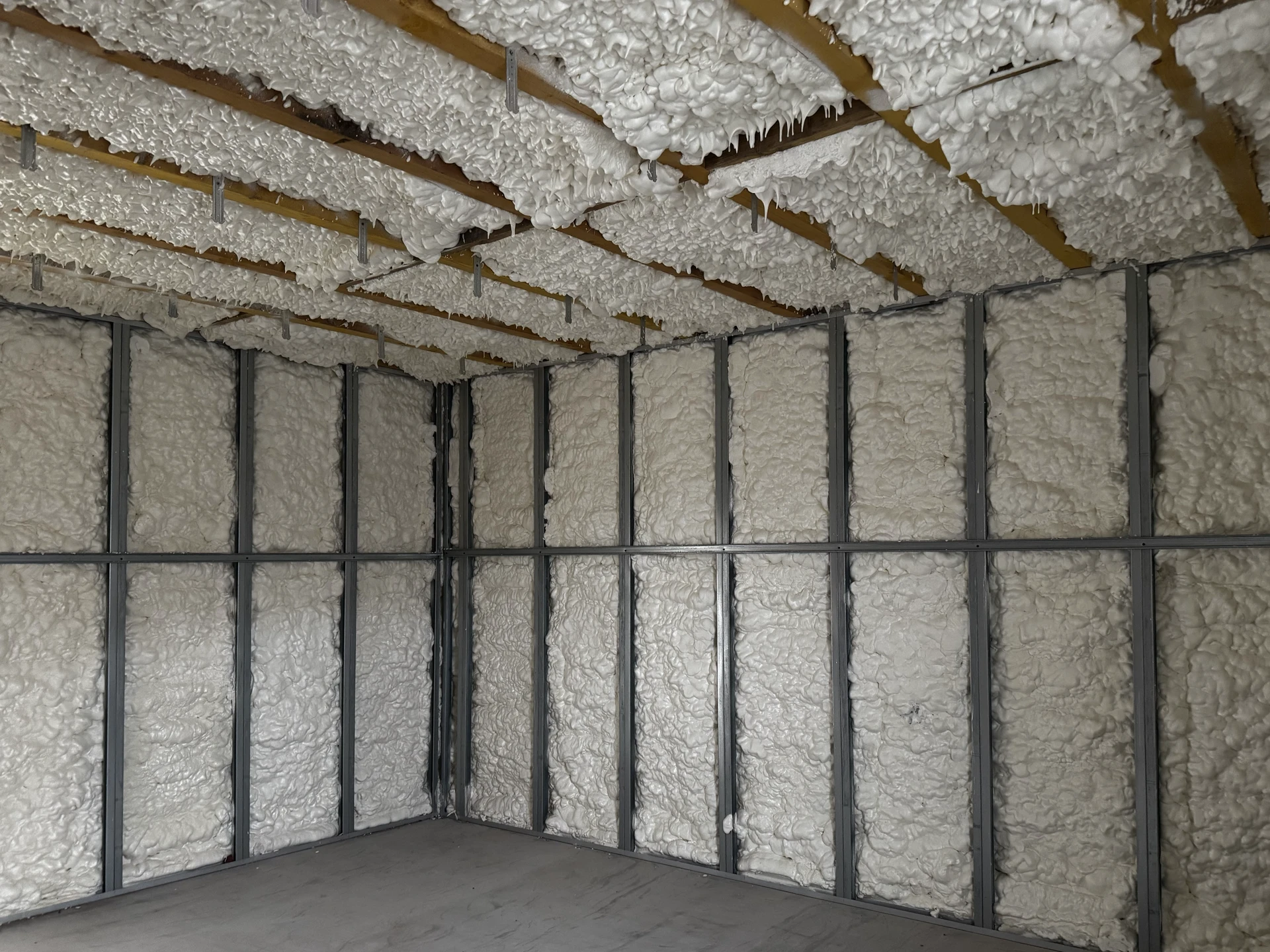 Chantier intérieur en cours d'isolation thermique par projection de mousse polyuréthane sur murs en parpaings